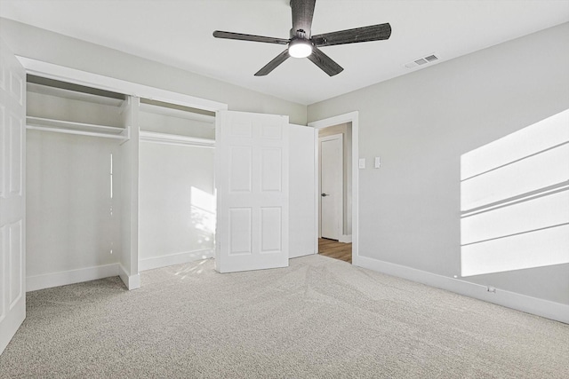 unfurnished bedroom with ceiling fan, light carpet, and a closet