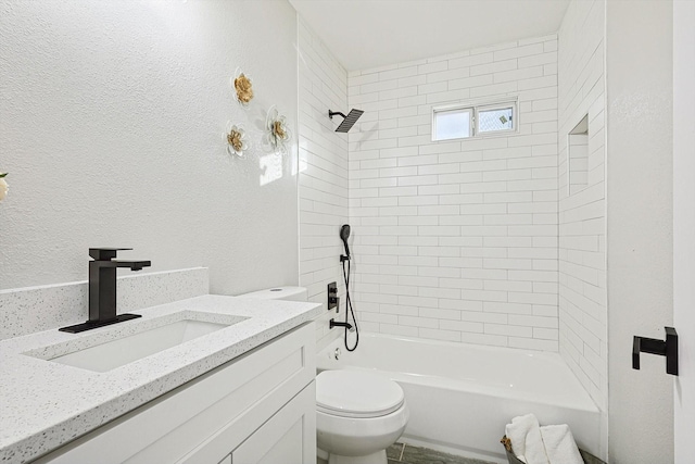 full bathroom with tiled shower / bath, vanity, and toilet