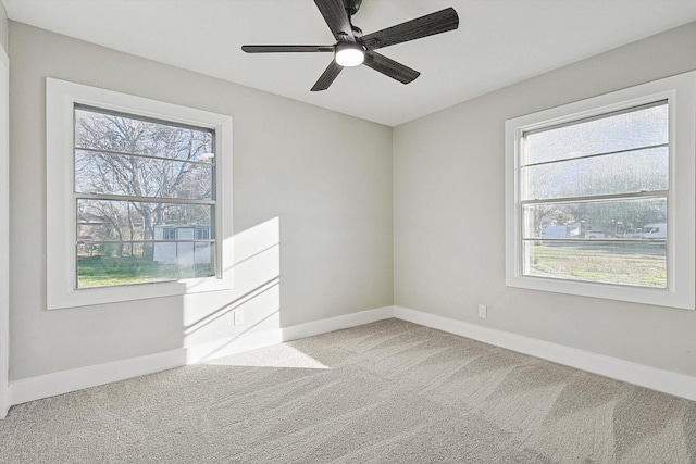 carpeted spare room featuring a wealth of natural light and ceiling fan