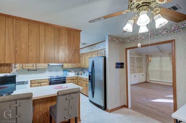 kitchen with stainless steel refrigerator with ice dispenser, a kitchen bar, kitchen peninsula, electric stove, and exhaust hood