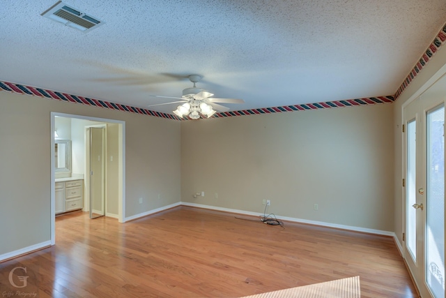 unfurnished room with ceiling fan, light hardwood / wood-style floors, and a textured ceiling