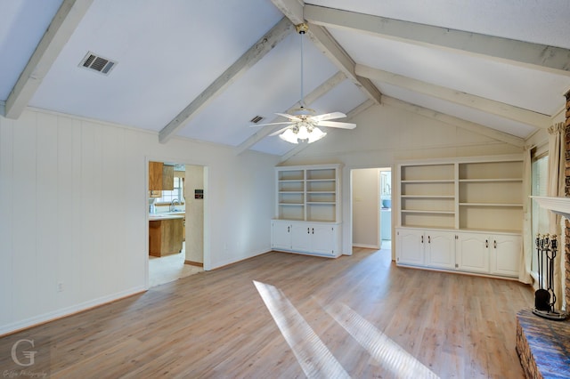 unfurnished living room featuring built in shelves, sink, a fireplace, vaulted ceiling with beams, and light hardwood / wood-style floors