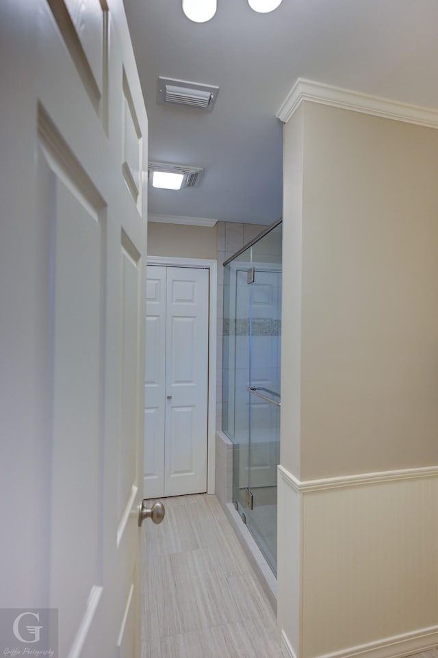 bathroom featuring walk in shower and crown molding