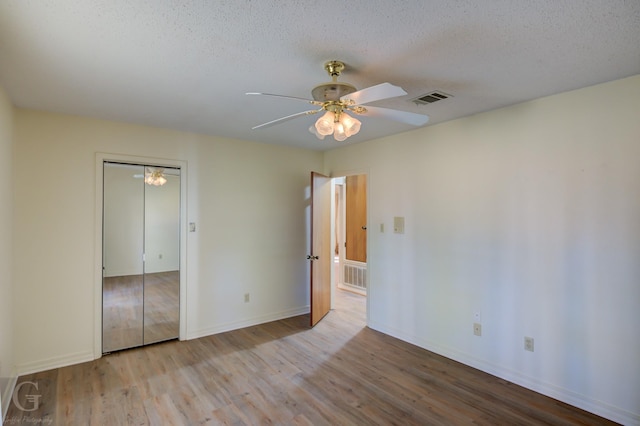 unfurnished bedroom with ceiling fan, a textured ceiling, and a closet