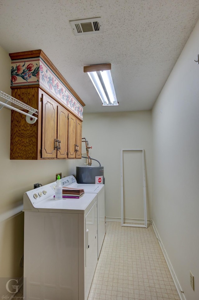 laundry room with cabinets, independent washer and dryer, a textured ceiling, and water heater