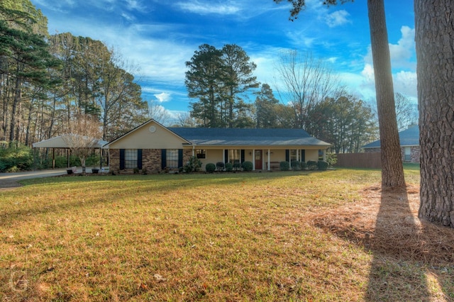 ranch-style house featuring a front yard, a carport, and covered porch