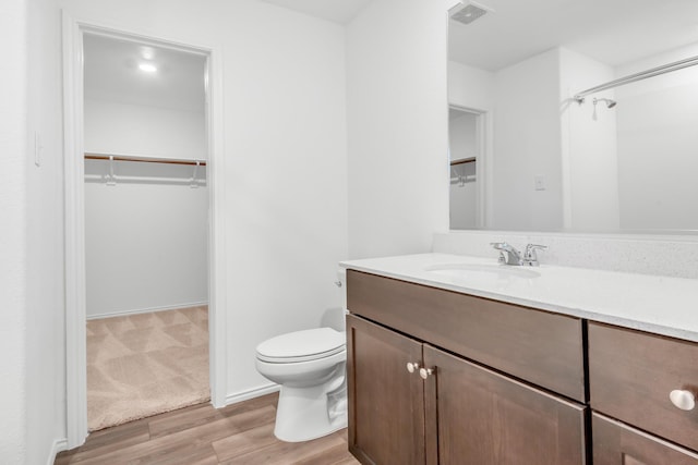 bathroom with vanity, toilet, and wood-type flooring