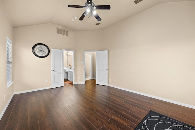 unfurnished bedroom featuring ceiling fan, lofted ceiling, dark wood-type flooring, and connected bathroom