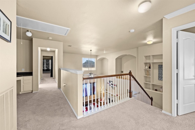 corridor with built in features and light colored carpet