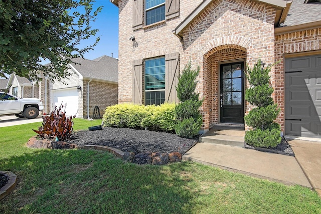 view of exterior entry featuring a lawn