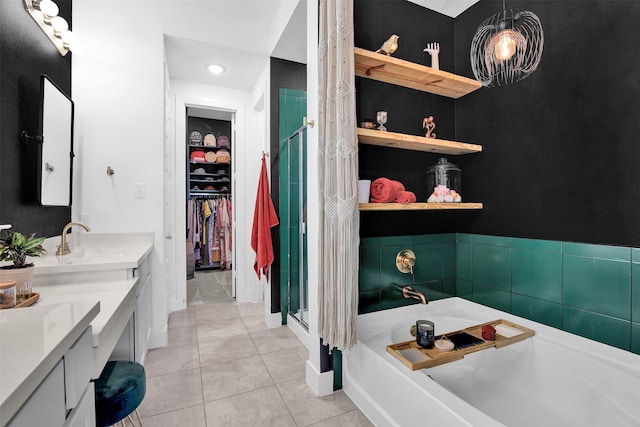 bathroom featuring shower with separate bathtub, vanity, and tile patterned floors