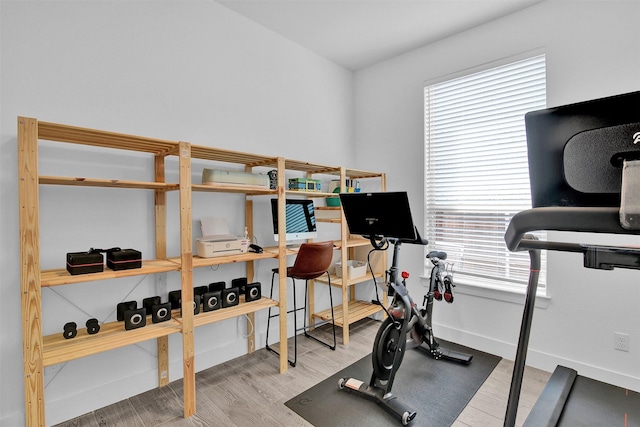 exercise room with light hardwood / wood-style floors