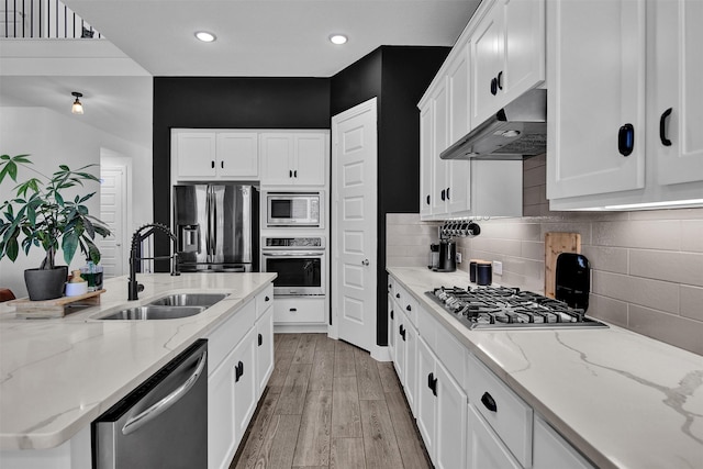 kitchen with sink, white cabinets, extractor fan, and appliances with stainless steel finishes