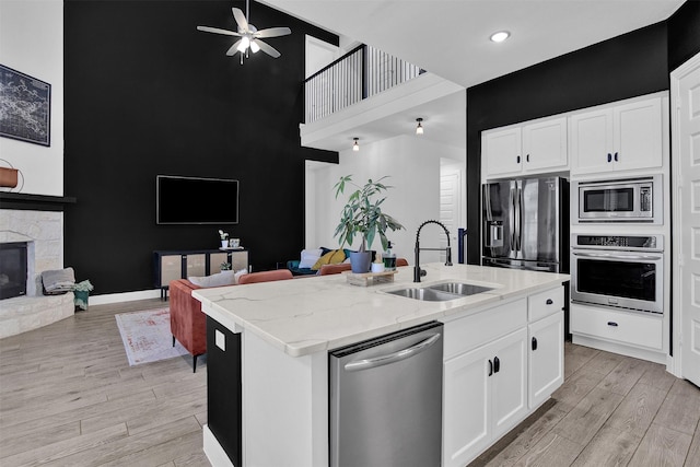 kitchen featuring white cabinetry, a kitchen island with sink, sink, and appliances with stainless steel finishes