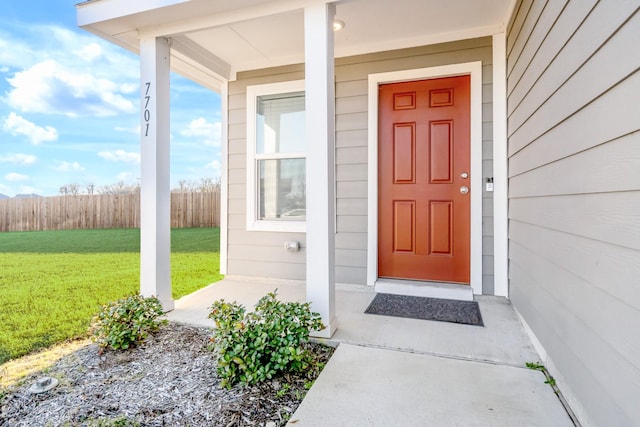 property entrance with a lawn