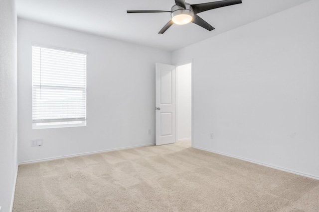 spare room with light colored carpet and ceiling fan