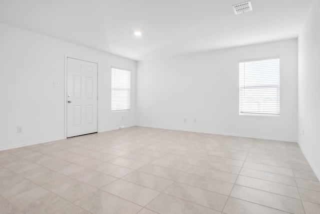 spare room featuring light tile patterned floors and plenty of natural light