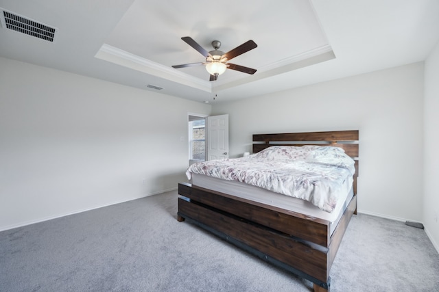 carpeted bedroom with crown molding, a raised ceiling, and ceiling fan