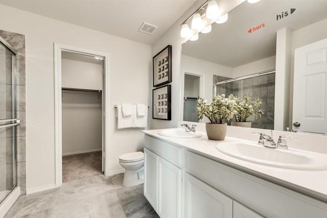 bathroom with vanity, a shower with door, and toilet