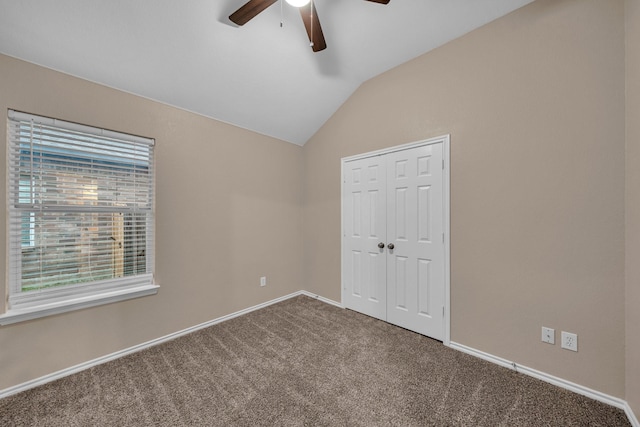 unfurnished bedroom with vaulted ceiling, carpet floors, ceiling fan, and a closet