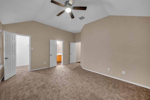 unfurnished bedroom featuring lofted ceiling, ensuite bathroom, and carpet