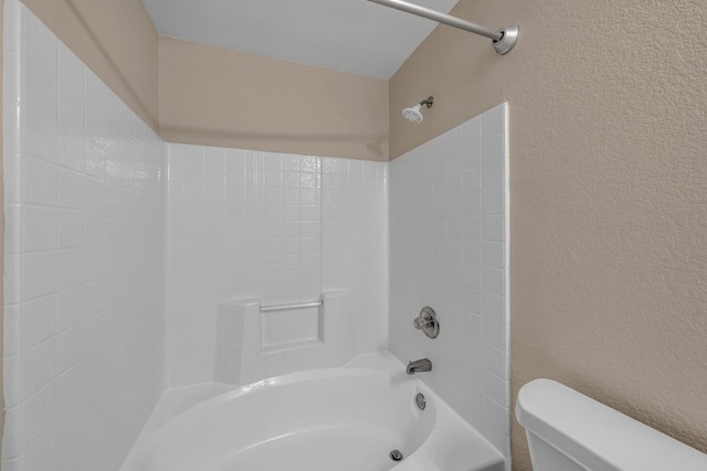 bathroom featuring shower / bathtub combination and toilet