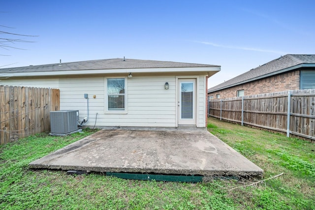 rear view of house featuring central AC unit, a yard, and a patio area