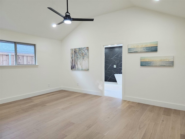 spare room with light hardwood / wood-style floors, vaulted ceiling, and ceiling fan