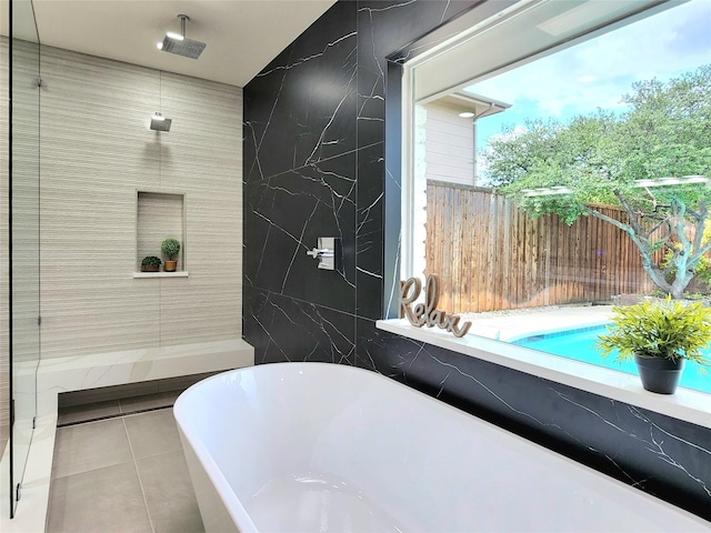 bathroom featuring tile patterned flooring, shower with separate bathtub, tile walls, and a healthy amount of sunlight