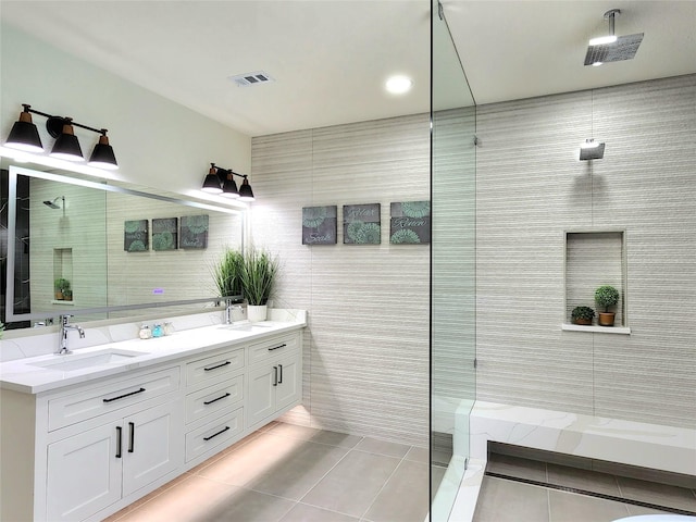 bathroom featuring tile patterned floors, vanity, tile walls, and tiled shower