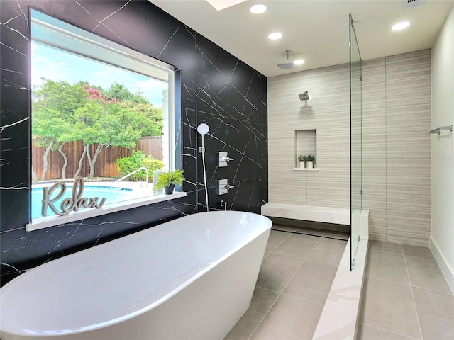 bathroom featuring tile patterned flooring, shower with separate bathtub, and tile walls