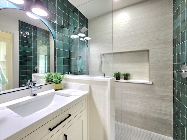 bathroom featuring a tile shower and vanity