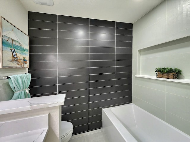 bathroom featuring tile patterned flooring, vanity, tile walls, and toilet