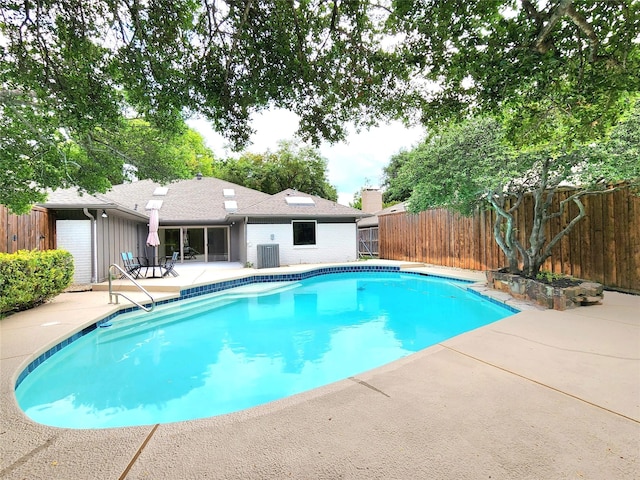 view of pool with cooling unit and a patio area