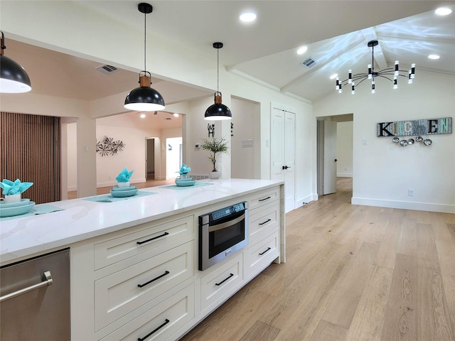 kitchen featuring lofted ceiling, hanging light fixtures, light hardwood / wood-style floors, light stone counters, and white cabinetry