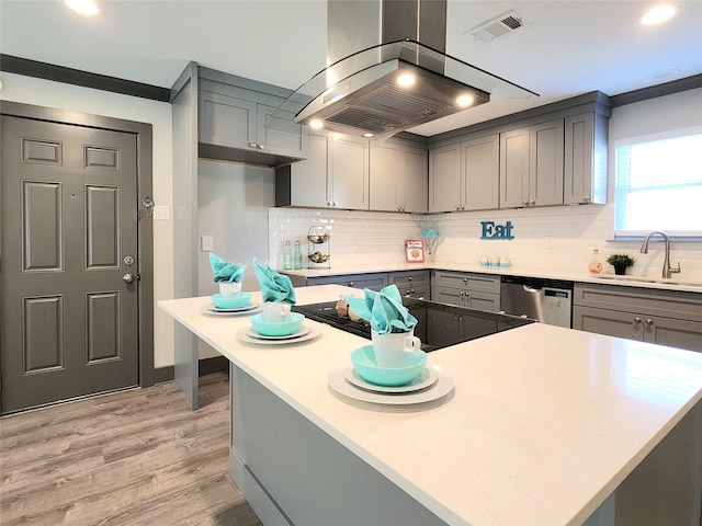 kitchen featuring sink, island range hood, gray cabinets, and stainless steel dishwasher