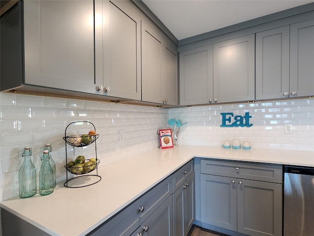 kitchen featuring gray cabinetry, dishwasher, and tasteful backsplash