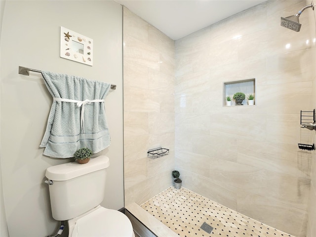 bathroom with a tile shower and toilet