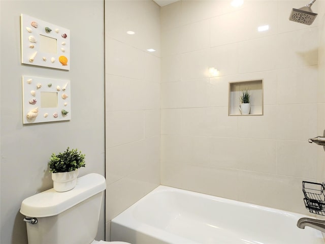 bathroom featuring tiled shower / bath combo and toilet