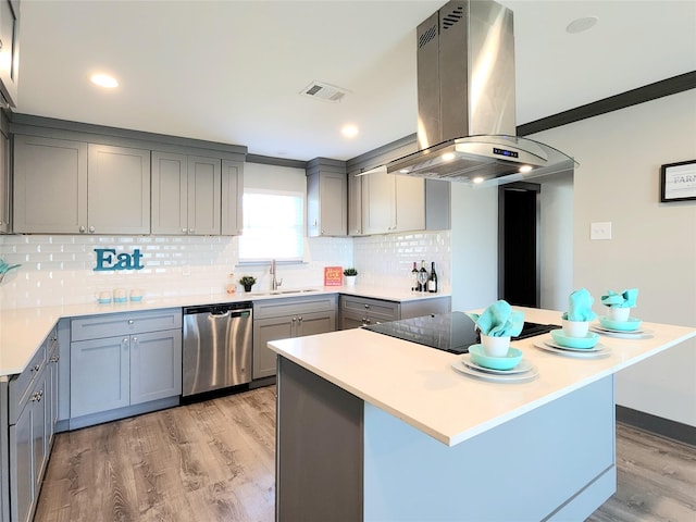 kitchen with gray cabinetry, sink, stainless steel dishwasher, island exhaust hood, and light hardwood / wood-style floors