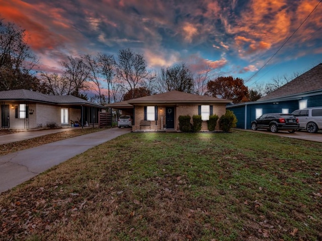 ranch-style house featuring a carport and a lawn