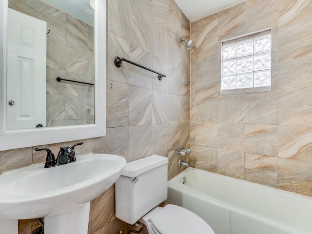 full bathroom featuring toilet, tile walls, sink, and tiled shower / bath