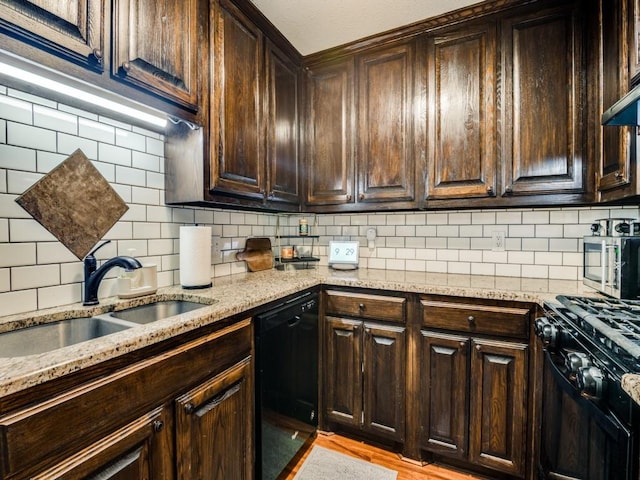 kitchen featuring tasteful backsplash, light stone counters, and black appliances