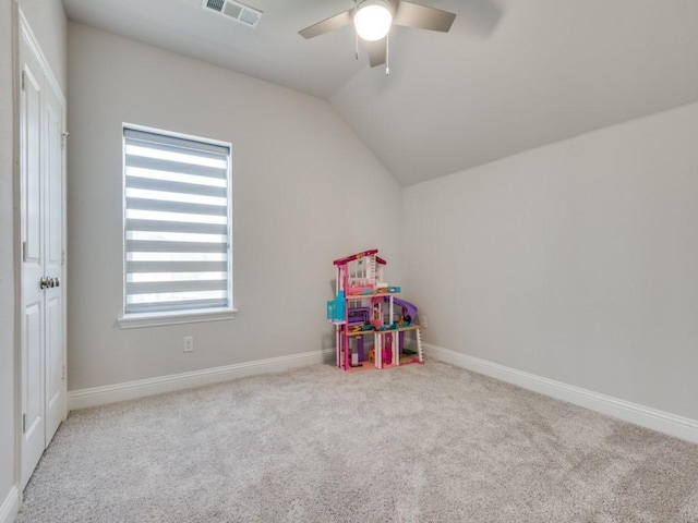 playroom with ceiling fan, vaulted ceiling, and light carpet