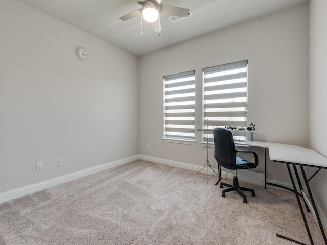 carpeted office space featuring ceiling fan