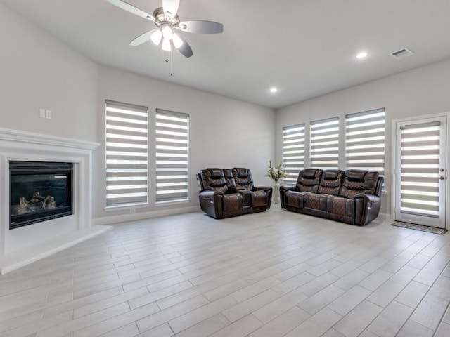 living room with a wealth of natural light, ceiling fan, and light wood-type flooring