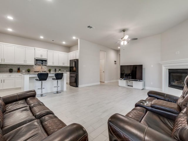 living room with ceiling fan and light hardwood / wood-style floors