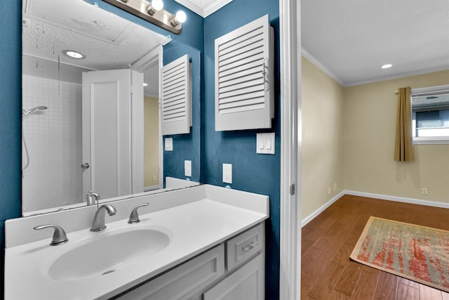 bathroom featuring hardwood / wood-style floors, vanity, ornamental molding, a shower, and a textured ceiling