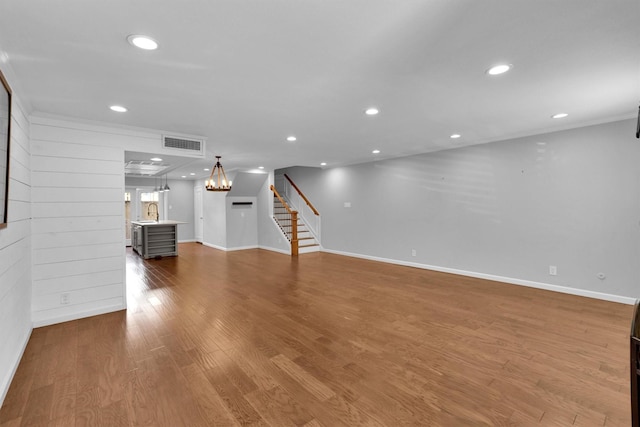 unfurnished living room with hardwood / wood-style floors and a notable chandelier