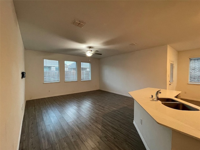 unfurnished living room with ceiling fan, sink, and dark hardwood / wood-style floors